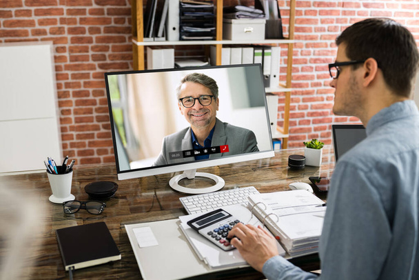 Financial Tax Advisor Looking At Invoice In Video Conference With Client - Foto, Imagem