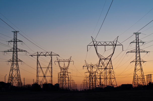 Sähkönsiirtotornit (sähköpanssarivaunut) auringonlaskun aikaan
 - Valokuva, kuva
