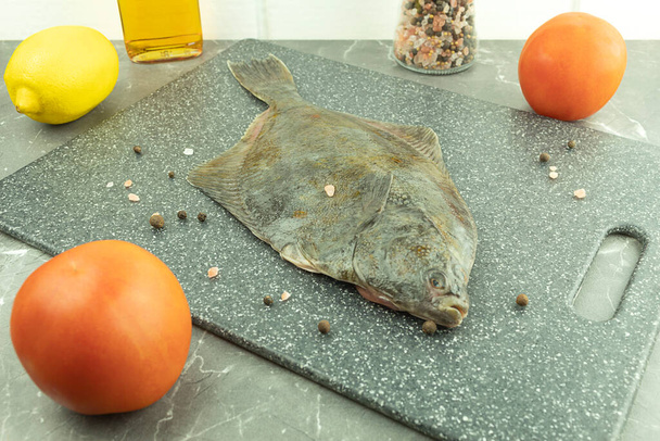 Fresh fish with spices on a cutting board close-up. Fresh fish flounder and sea salt with spices - Photo, Image