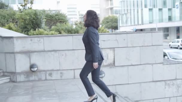 Keski-ikäinen valkoihoinen liikenainen puvussa kävelee yläkertaan - Materiaali, video