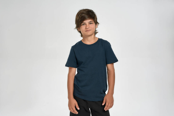 Little sportive boy child in sportswear smiling at camera, posing while standing isolated over white background - Foto, Imagen