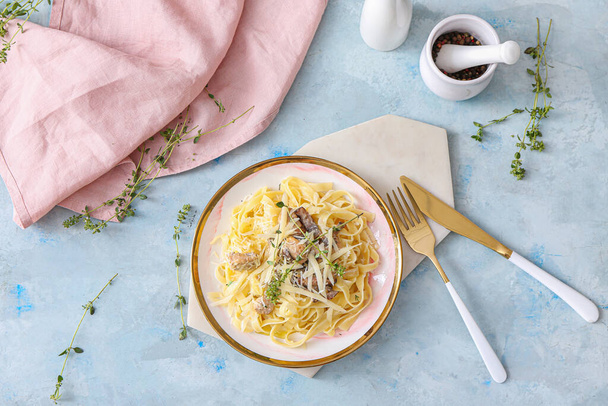 Plaat van smakelijke pasta met kip en champignons op kleurtafel - Foto, afbeelding