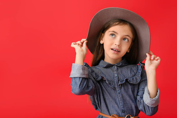 Милая маленькая девочка в осенней одежде на цветном фоне - Фото, изображение