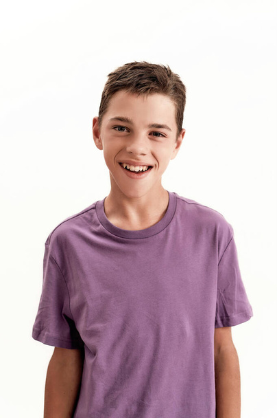 Close up portrait of happy teenaged disabled boy with cerebral palsy smiling at camera, posing isolated over white background - Фото, зображення