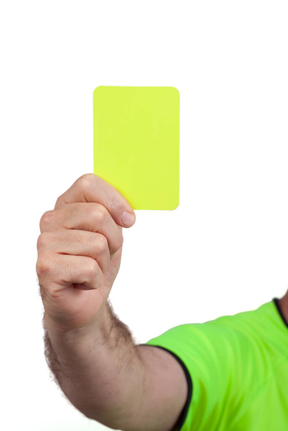 Carton jaune dans la main de l'arbitre de football de football isolé sur fond blanc. L'image contient le chemin de coupe. - Photo, image
