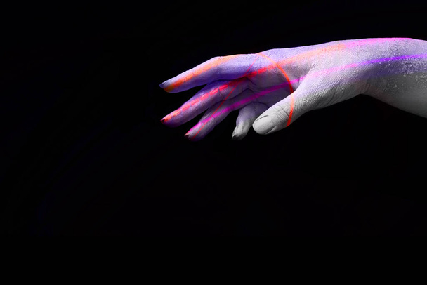 Eine schöne weibliche, farbenfrohe Hand mit trockener Haut streckt Ihr Produkt auf einem schwarzen, isolierten Hintergrund, Konzeptkunst - Foto, Bild