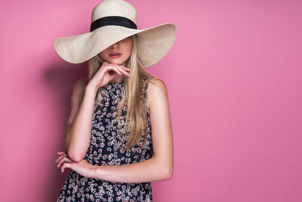 Beauty photo of attractive sensual woman wearing straw brimmed hat, posing on pink studio background - Фото, зображення