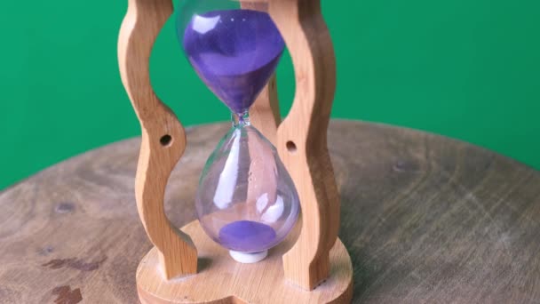 Hipnótico un minuto corriendo reloj de arena vintage en mesa de madera y pantalla verde. - Metraje, vídeo