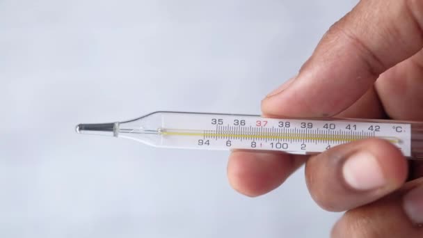 homme main tenant thermomètre médical sur fond blanc  - Séquence, vidéo