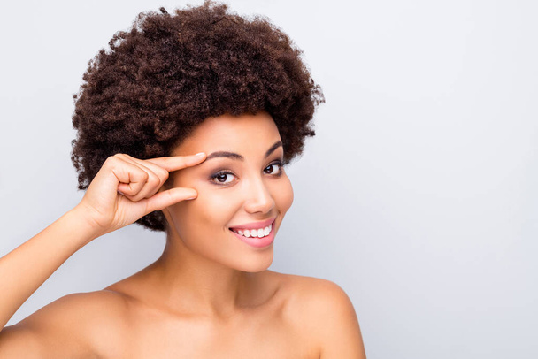 Nahaufnahme Foto von charmanten afroamerikanischen Mädchen genießen Augen Lifting Verwöhnverfahren machen die Haut makellos glatt seidig glänzend ideal reines Wohlbefinden isoliert über graue Farbe Hintergrund - Foto, Bild