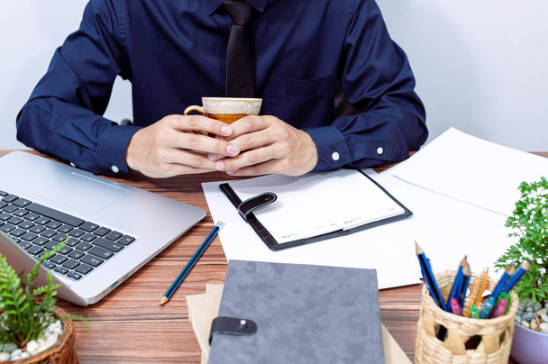 zakenman die koffie drinkt aan zijn bureau - Foto, afbeelding