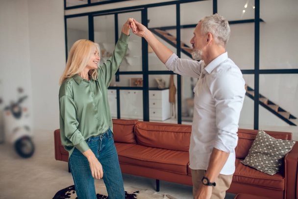 Man and woman dancing in the room and looking enjoyed - Фото, изображение