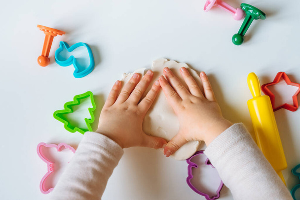 Vista da vicino delle mani del bambino che giocano con l'impasto fatto in casa. Gioco creativo per bambini per lo sviluppo precoce e le abilità motorie. - Foto, immagini