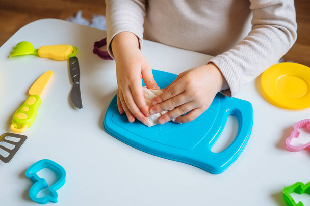 Close view of child's hands playing with homemade playdough. Children's creative game for early development and fine motor skills. - Foto, Bild