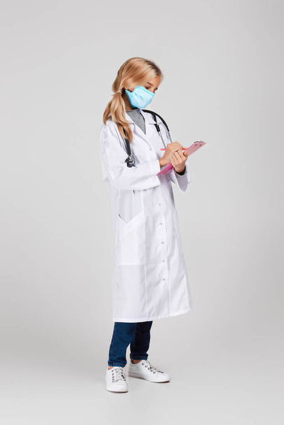 Aranyos gyermek orvosi köpenyben sztetoszkóppal - Fotó, kép