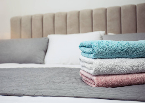 Stack of clean towels on bed, closeup. Space for text - Foto, Bild