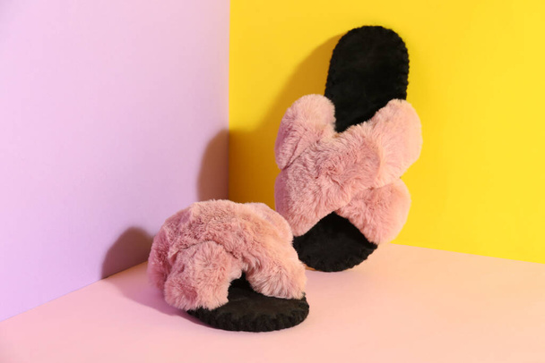 Pair of soft slippers on color background - 写真・画像