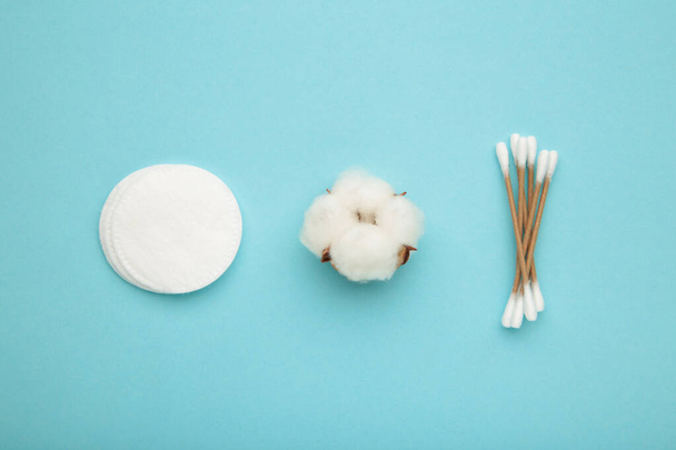 Cotton swabs and sticks with flower on blue background. Top view - Foto, immagini