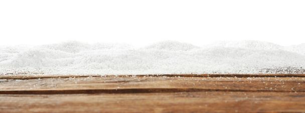 Artificial snow on wooden table against white background. Christmas decor - Fotó, kép