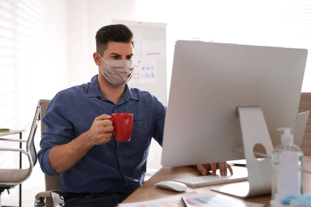Worker with mask in office. Protective measure during COVID-19 pandemic - Fotó, kép