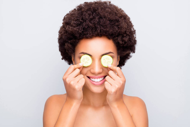 Close-up portrait of nice attractive cheerful healthy wavy-haired girl holding in hand cucumber pieces anti age treatment closing eyes binocular isolated on light white gray color pastel background - Fotoğraf, Görsel