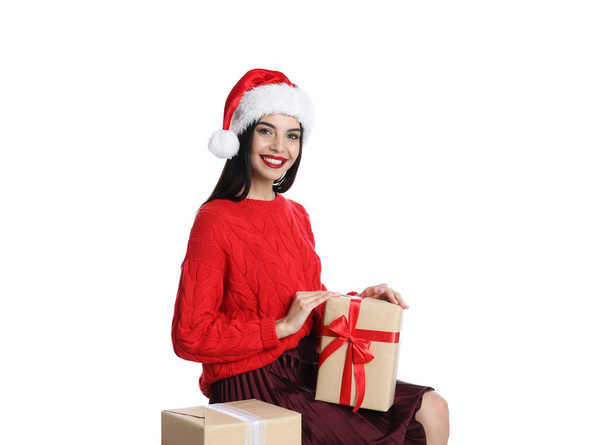 Woman in red sweater and Santa hat with Christmas gifts on white background - Foto, Imagem