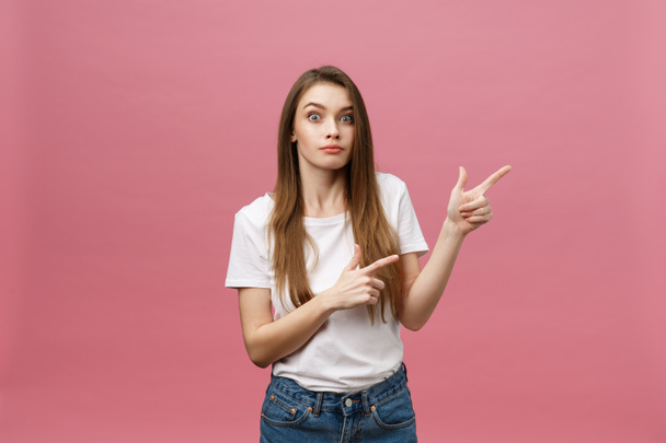Woman pointing finger at camera and toothy smiling. Expression emotion and feelings concept. Studio shot, isolated on pink background - Photo, Image