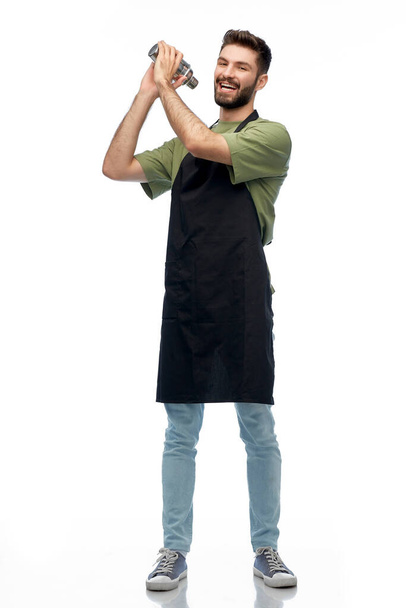 happy barman in apron with shaker preparing drink - Φωτογραφία, εικόνα