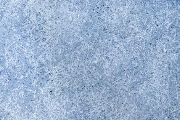 Blick von oben auf vom Sonnenlicht beleuchtete Schneekristalle, Nahaufnahme. Winterlicher Hintergrund. - Foto, Bild