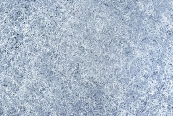 Horní pohled na sněhové krystaly osvětlené slunečním světlem, záběr zblízka. Zimní pozadí. - Fotografie, Obrázek