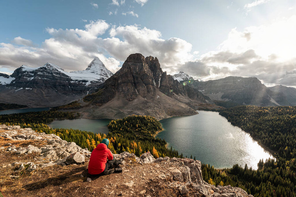 Góra Assiniboine z skalistymi górami i jeziorem w jesiennym lesie w parku prowincjonalnym, BC, Kanada. Podróżnik relaksujący się na Niblet - Zdjęcie, obraz