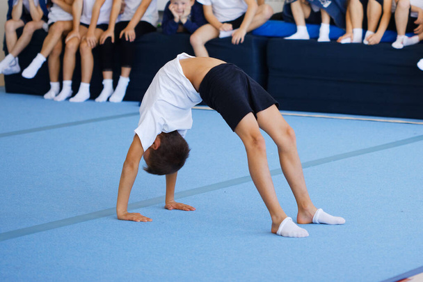 αγόρι που εκτελεί γυμναστικές ασκήσεις στο γυμναστήριο 2020 - Φωτογραφία, εικόνα