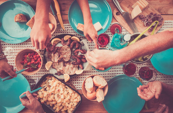 Vista dall'alto degli amici che mangiano insieme cibo sul tavolo nella celebrazione dell'amicizia  - Foto, immagini