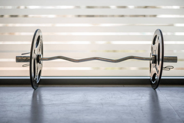 Barbells by the window in an indoor gym, with copy space.  - Photo, Image