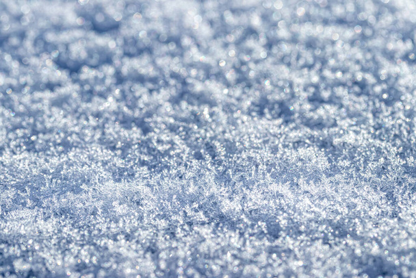 Крупный план снежных кристаллов, освещенных солнечным светом. Зимний фон. - Фото, изображение