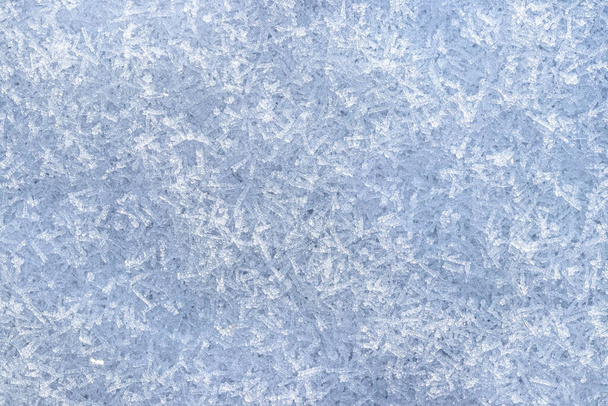 Κοντινό πλάνο κρυστάλλων χιονιού φωτισμένων από το φως του ήλιου. Χειμερινό υπόβαθρο. - Φωτογραφία, εικόνα