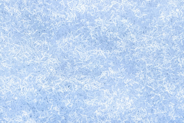 Κάτοψη των κρυστάλλων χιονιού φωτίζεται από το φως του ήλιου, πυροβόλησε από κοντά. Χειμερινό υπόβαθρο. - Φωτογραφία, εικόνα