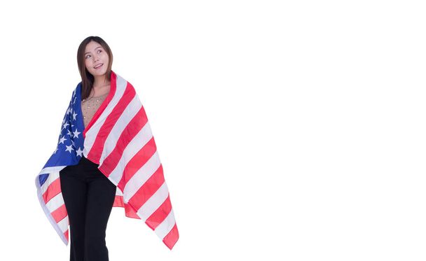 Młoda kobieta używająca flagi USA zakrywającej ramiona białym tłem. Miejsce na tekst. 4 lipca. Świętujcie Amerykański Dzień Narodowy. Święto Pracy. Dzień Niepodległości. - Zdjęcie, obraz