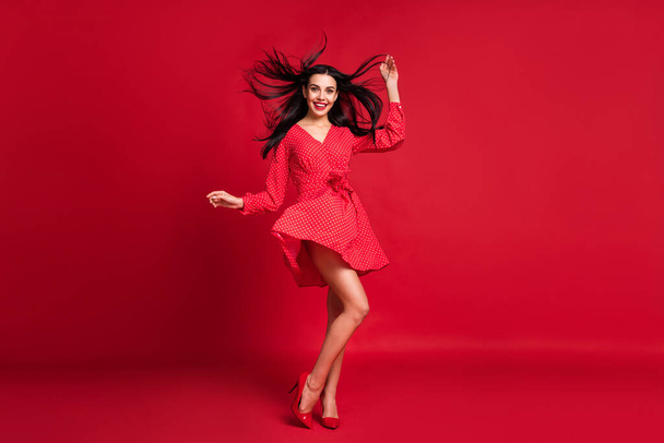 Full length body size view of adorable slim cheerful model posing having fun wind blowing hairstyle isolated on bright red color background - Φωτογραφία, εικόνα