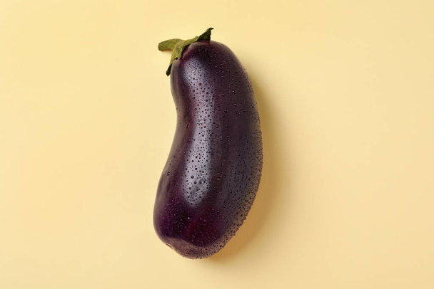 Fresh raw eggplant with water drops on beige  background - Foto, Bild