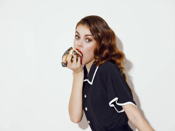 συναισθηματική γυναίκα τρώει κέικ κόκκινα χείλη απολαμβάνοντας γλυκά - Φωτογραφία, εικόνα