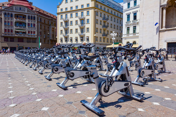 Ομάδα ποδηλάτων γυμναστικής εσωτερικού χώρου τοποθετούνται στην πλατεία της πόλης έτοιμα για προπόνηση. - Φωτογραφία, εικόνα