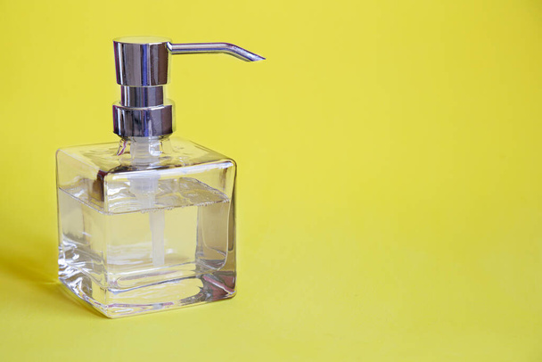Soap dispenser against yellow background - Photo, Image