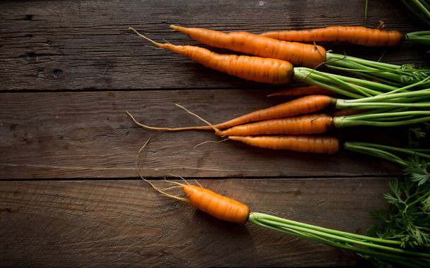 Fresh carrots bunch on rustic background. Healthy vegan vegetable food. - Foto, Imagen