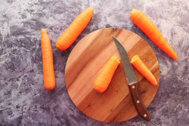 fresh carrots on chopping board on table  - Fotó, kép