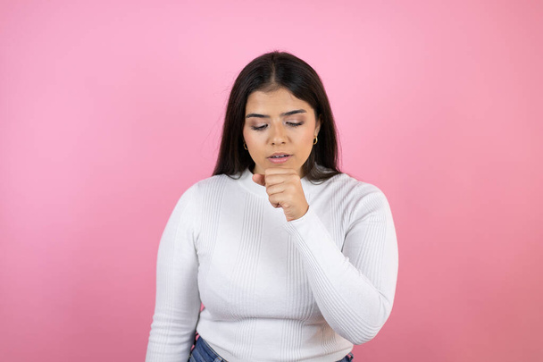 Young beautiful woman over isolated pink background with her hand to her mouth because she's coughing - Photo, Image