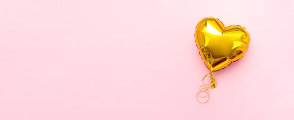 Wide banner with Golden heart foil balloon upper view on pink Valentines Day background. Copyspace - Foto, imagen