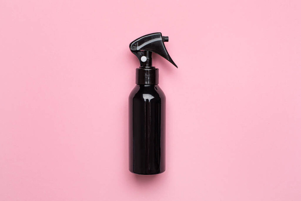 Black spray bottle on pastel pink background top view - Photo, image