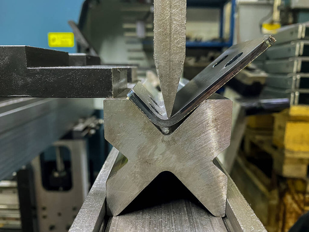 Metal levha bükme makinesi kullanarak metal parçaların bükülmesi - Fotoğraf, Görsel