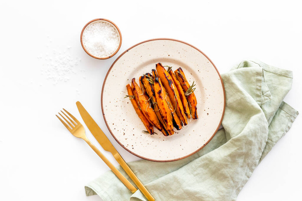 Pile of sweet potato fries with herbs on a plate, top view - Zdjęcie, obraz